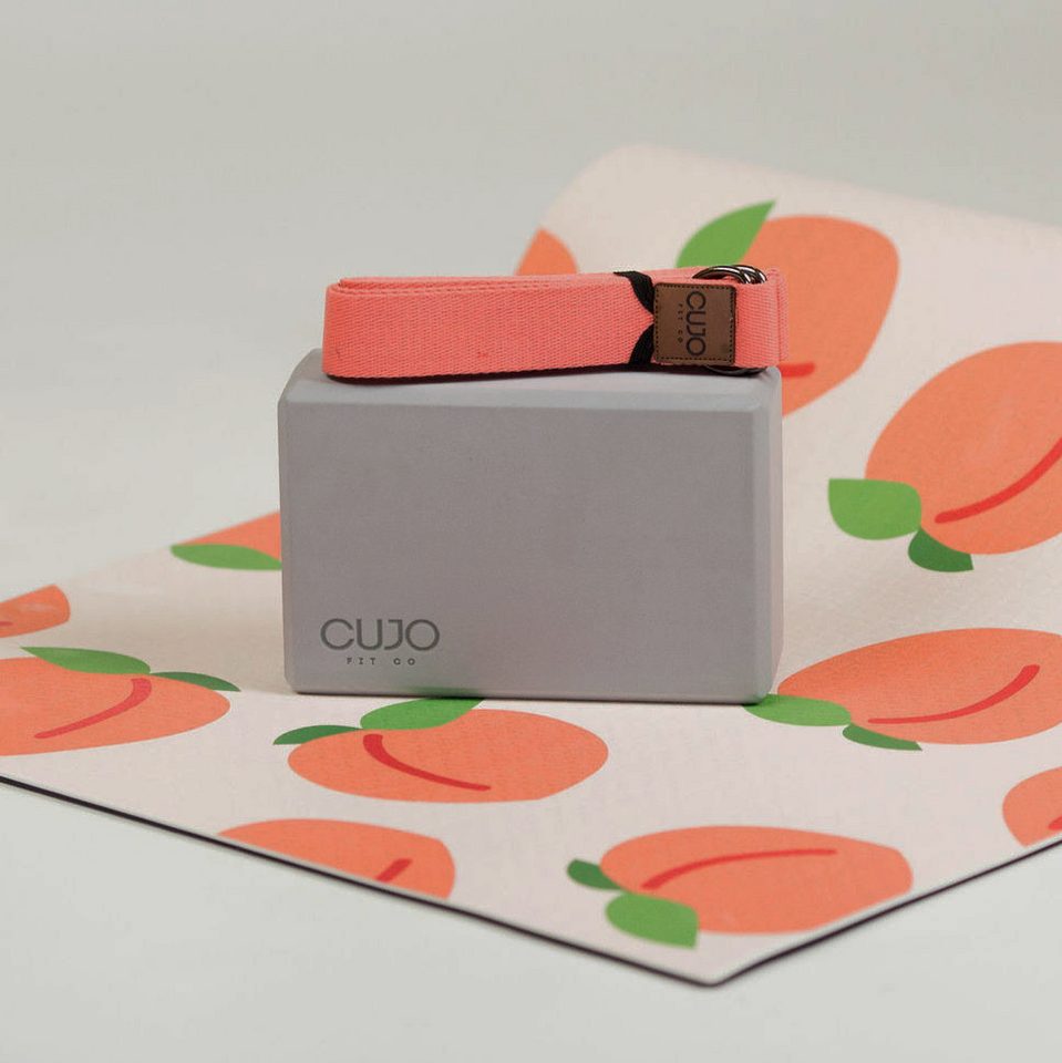 peach yoga mat with gray block and pink strap